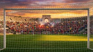 Estádio de futebol português ao entardecer com bancadas cheias de adeptos